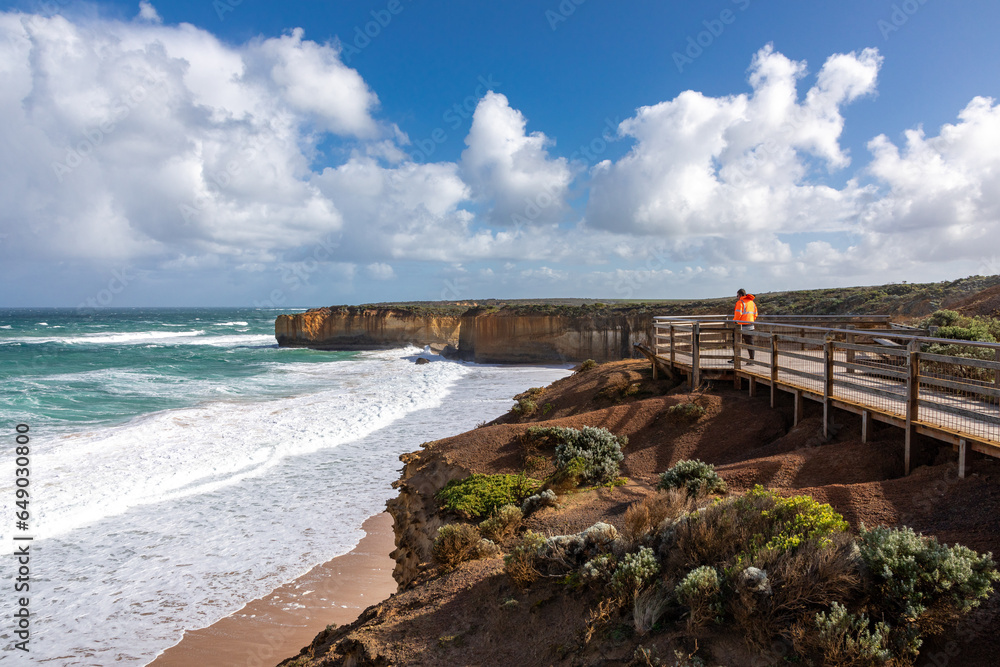 Man lookig at Twelve Apostles rock formations at the Great Ocean Road, Victoria, Australia