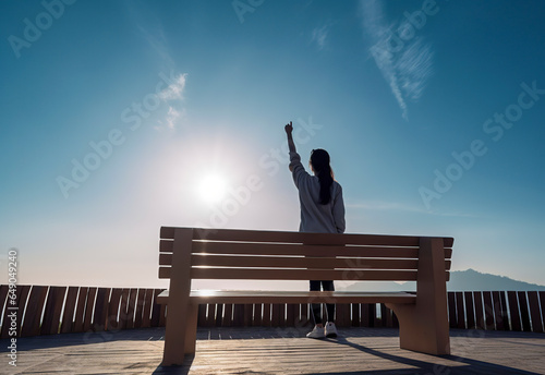 Triumphant Victory: A Young Woman's Joyful Gesture of Success by the Wooden Bench in Nature, ai generative