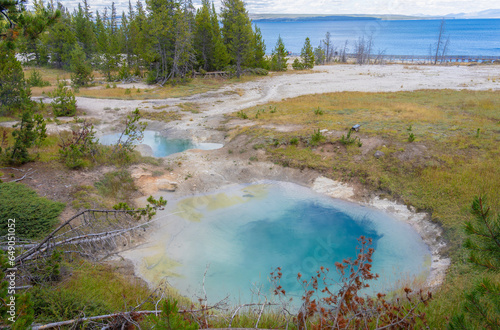 Seismograph pool with steamy water sits near Yellowstone Lake in Yellowstone National Park at West Thumb Geyser Basin. Water is hot and is surrounded by earth's thin crust.