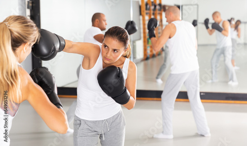 Photography Young latin american woman training boxing punches in sparring during group self