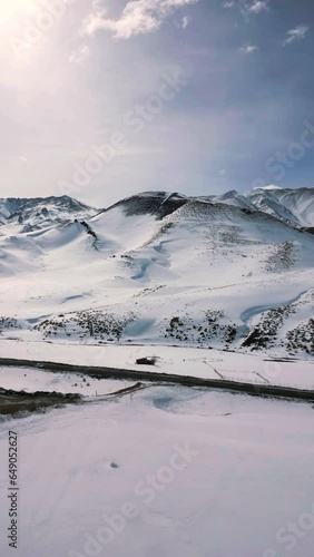 Vertical video of Aerial view drone flying over beautiful white snowy mountains