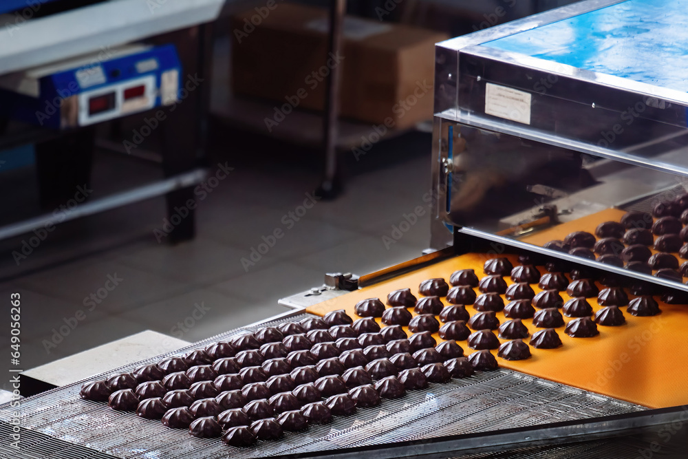 Process of chocolate glazing marshmallows in confectionery on conveyor machine, close up Process of chocolate glazing marshmallows in confectionery on conveyor machine, close up