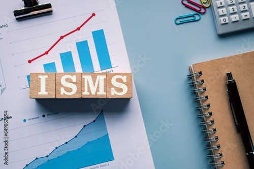 There is wood cube with the word ISMS. It is an abbreviation for Information Security Management System as eye-catching image. photo