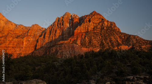 Mount Kinesava Glows Bright Orange Against A Blue Sky In The Backcountry of Zion