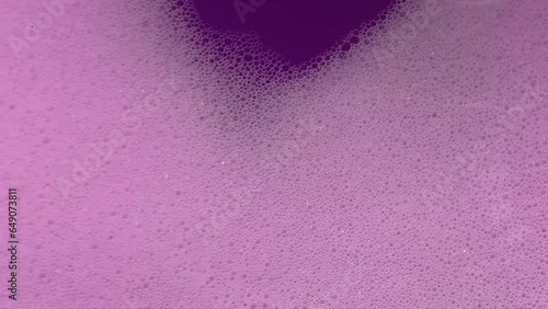 Bright pink foam in the washing machine drum, abstract liquid background, fuchsia bubbles texture