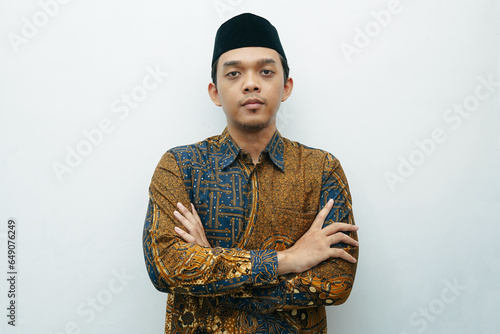 Portrait of Asian Indonesian man wearing batik shirt traditional cloth and black peci or songkok photo