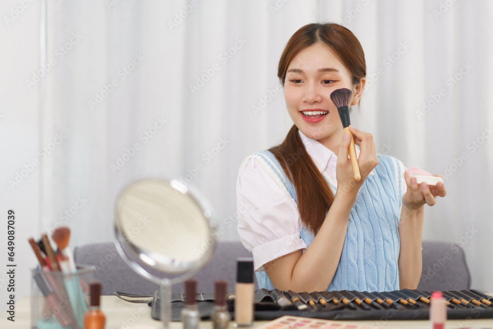 Beauty blogger concept, Asian woman apply blush on cheek to review makeup product in live streaming Beauty blogger concept, Asian woman apply blush on cheek to review makeup product in live streaming