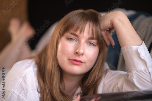 Obraz na plátně Young poet with long brown hair muses in her study by the light of a nearby window