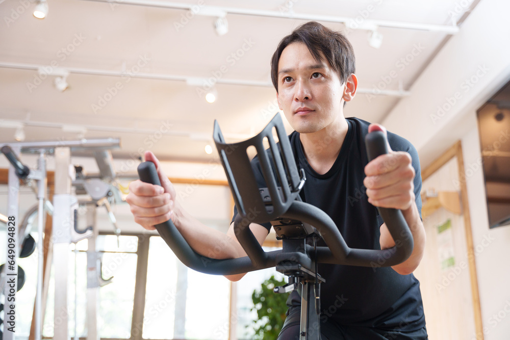 スポーツジムのエアロバイクで運動する男性(健康・ダイエット) スポーツジムのエアロバイクで運動する男性(健康・ダイエット)