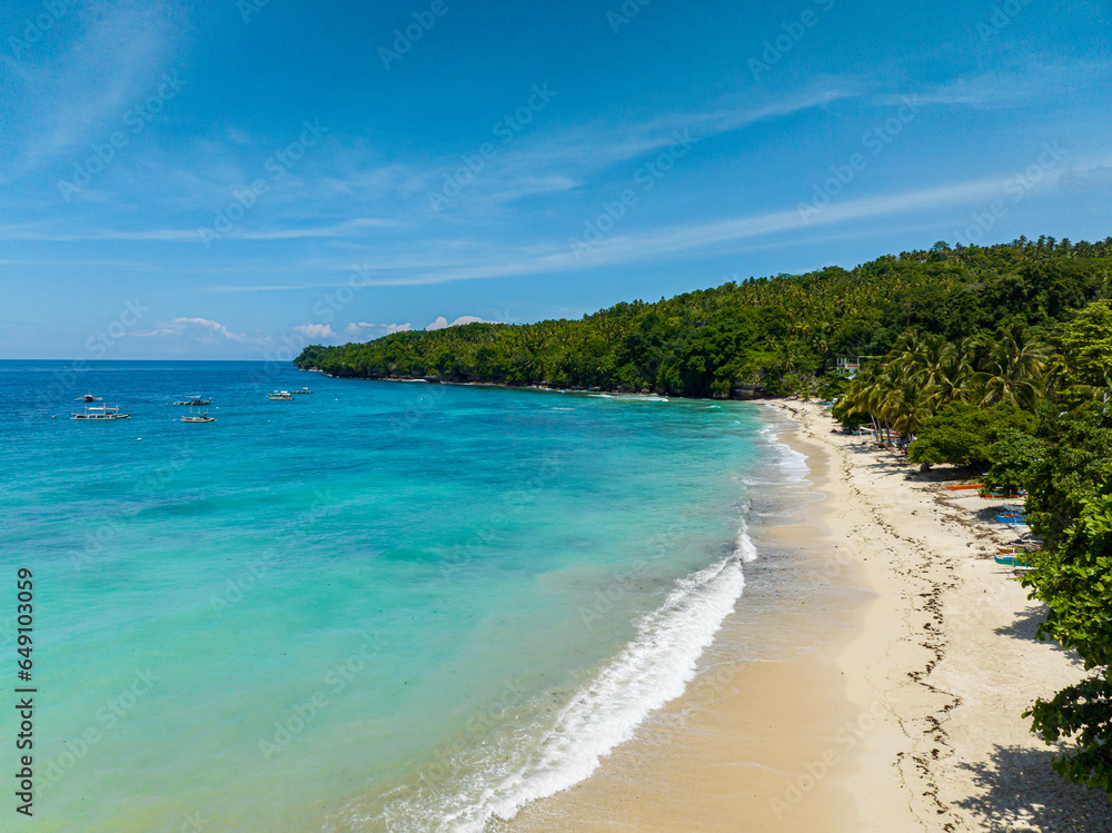 White sandy beach with turquoise sea water and waves. Samal Island. Davao, Philippines. White sandy beach with turquoise sea water and waves. Samal Island. Davao, Philippines.