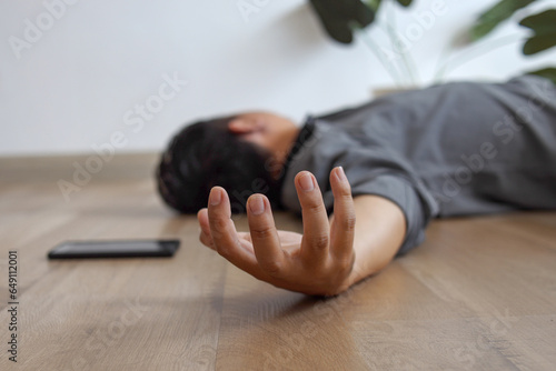 Foto Unconscious young man lying on floor with epileptic seizures at home, male injure at home