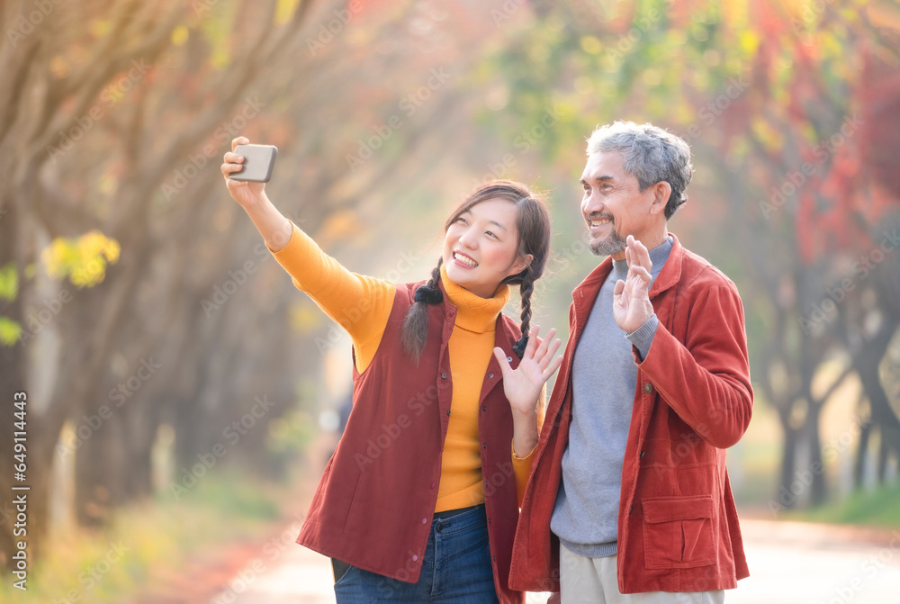 portrait young adult daughter and senior father smiling and taking a selfie together in autumn day outdoor,a family happy moment with love - obrazy, fototapety, plakaty 