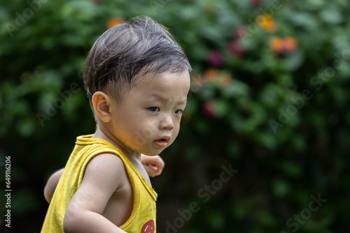 Portrait image of 1-2 years old little boy have a good time at the garden