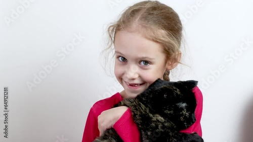 A little girl is stroking a cat. Close-up . White background