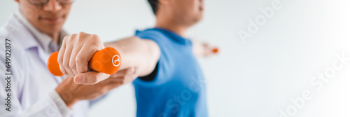 Physiotherapist man giving exercise with dumbbell treatment About Arm and Shoulder of athlete male patient Physical therapy concept