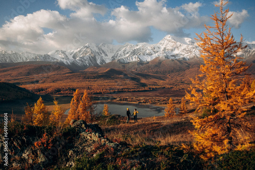 
couple in love on a lake in which mountains are reflecte