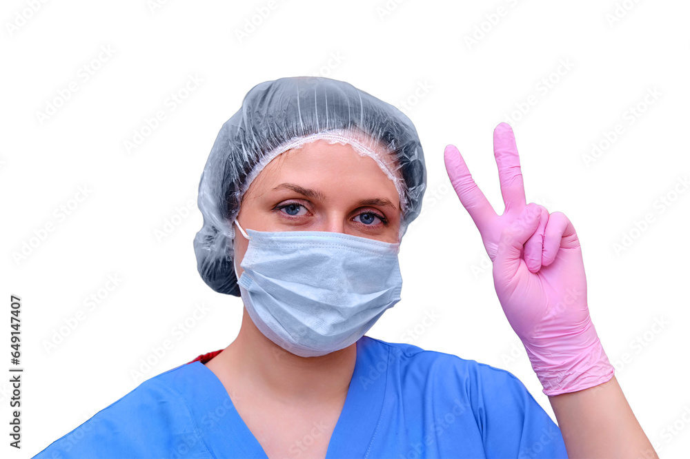 A female doctor in a medical mask on a shows a victory gesture, isolated on a white background. A medic with an approving hand sign, the concept of defeating the coronavirus epidemic. A female doctor in a medical mask on a shows a victory gesture, isolated on a white background. A medic with an approving hand sign, the concept of defeating the coronavirus epidemic.
