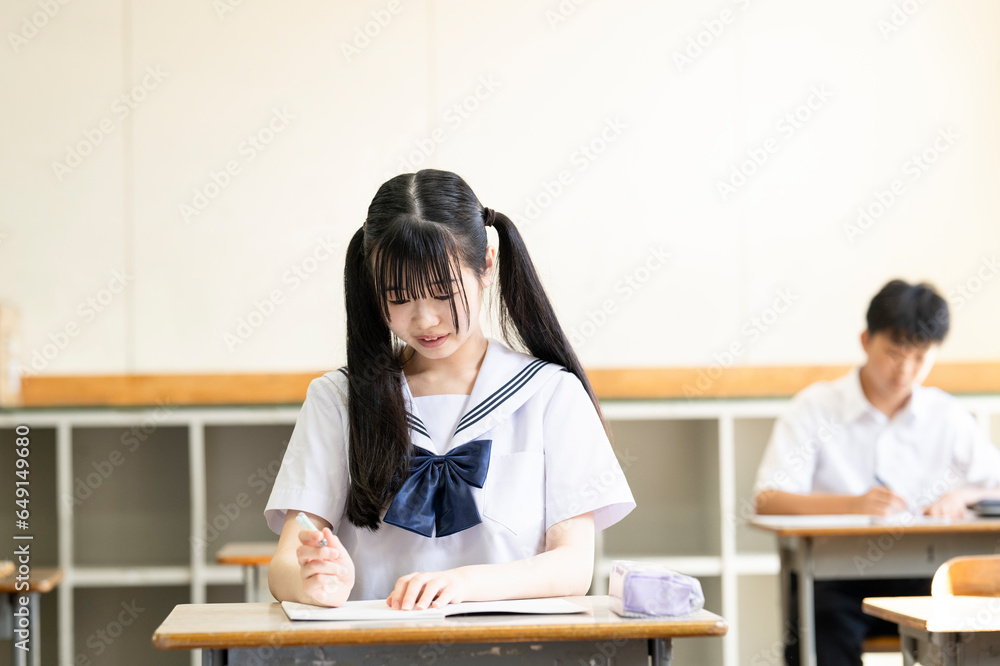 学校の教室で勉強する女子中学生 学校の教室で勉強する女子中学生
