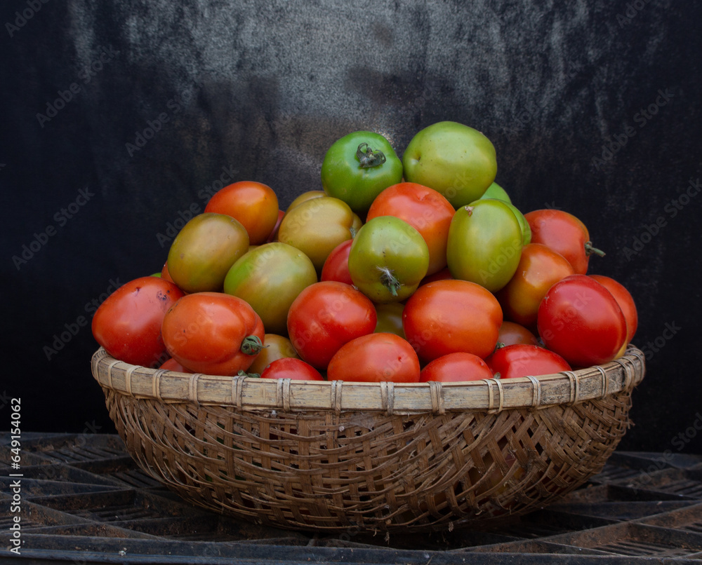 Green and ripe tomatoes give their name to a bamboo basket