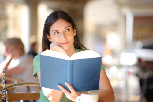 Book reader dreaming looking at side in a bar