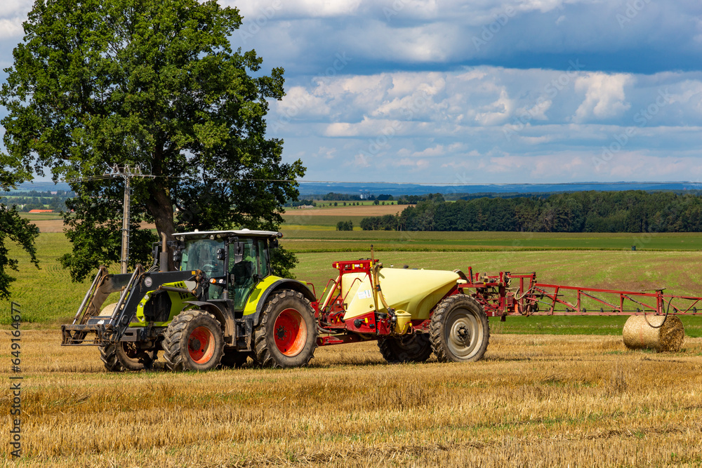 Obraz premium Agricultural machinery in summerfield. Rural landscape.