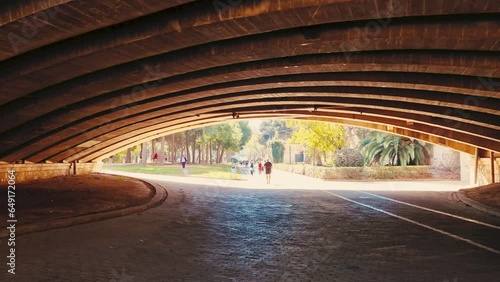 A walk through Turia Park in Valencia. A popular place for city residents and tourists for active recreation. Jogging and cycling paths under the bridge arch. photo