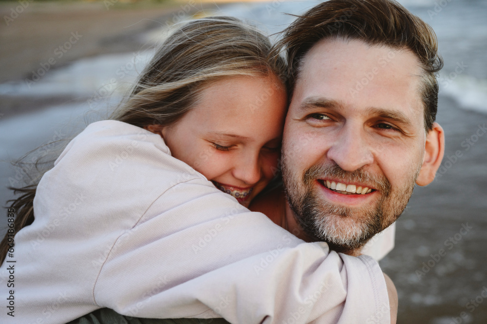 Happy daughter hugging father at beach Happy daughter hugging father at beach