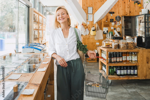 Smiling woman with basket shopping at zero waste store