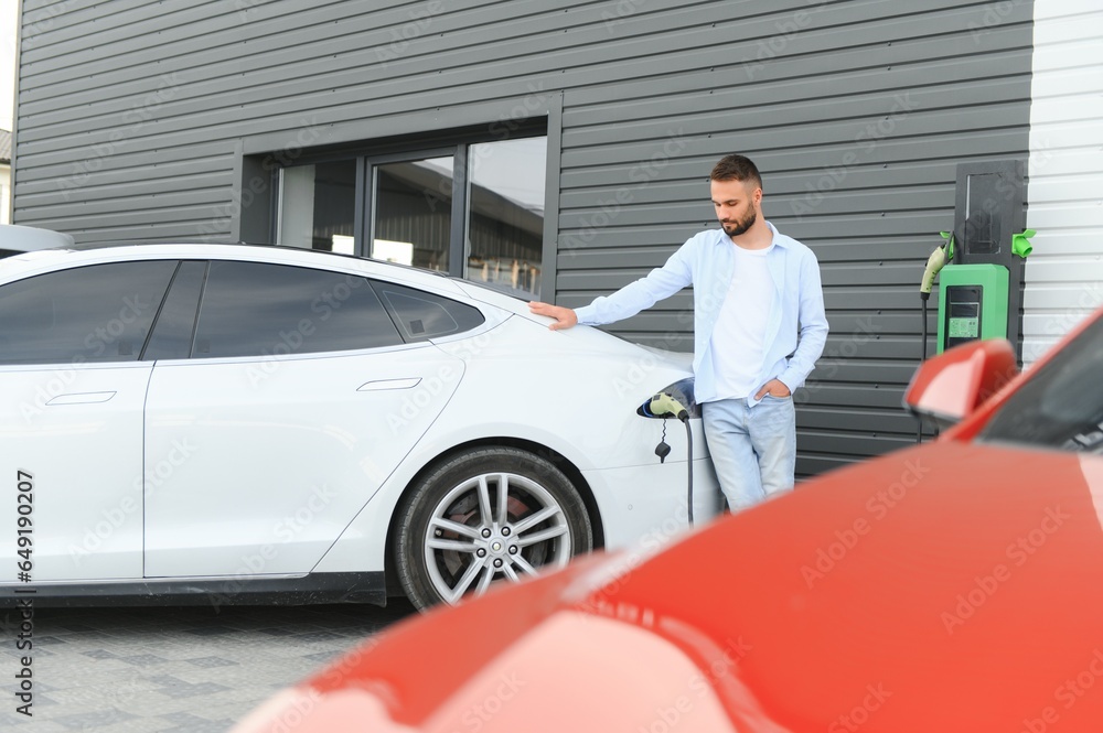Man standing by his electric car Man standing by his electric car