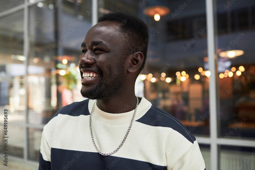 Obraz premium Candid close up portrait of smiling African American man looking away in city, copy space