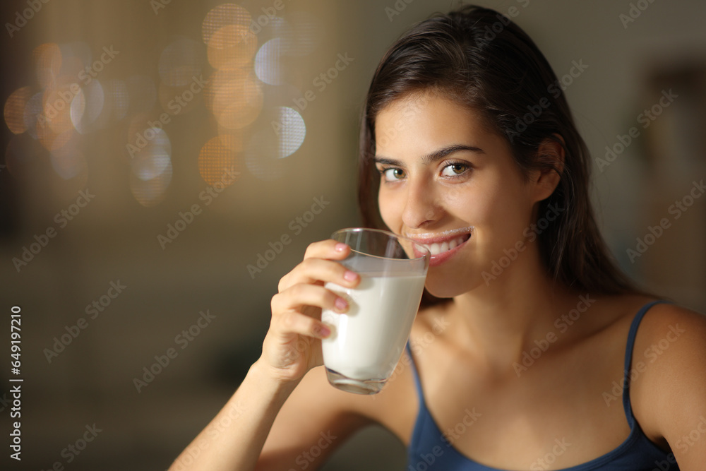 Happy woman drinking milk in the night at home Happy woman drinking milk in the night at home