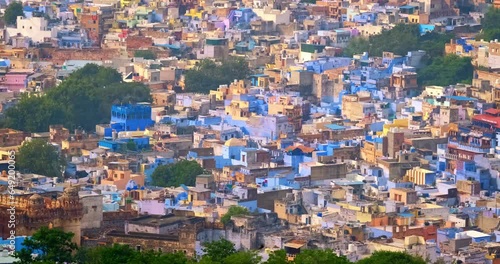 Houses of famous tourist landmark Jodhpur, the Blue City and birds, aerial view from Mehrangarh Fort, Rajasthan, India. Camera zoom out