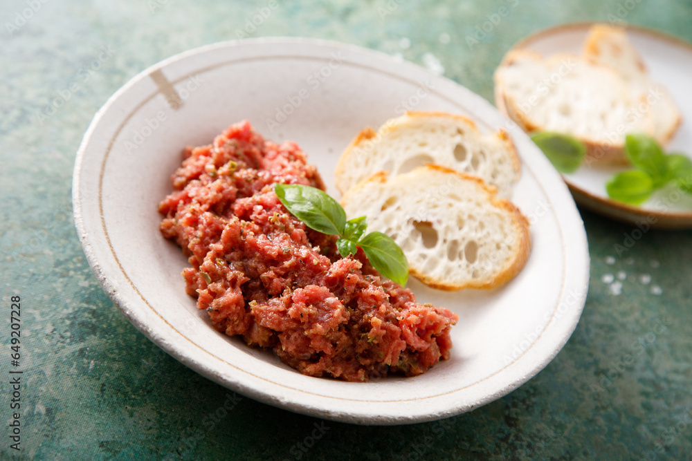 Traditional steak tartare with baguette bread Traditional steak tartare with baguette bread