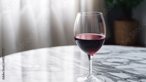 A glass of red wine in a studio closeup. Product photography. Glass of red wine standing on a table on a Marble background. Composition of red wine in a stem glass isolated.