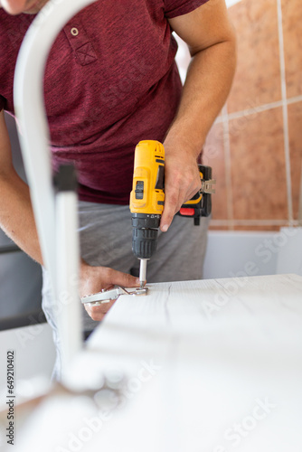 Wallpaper Mural Screwing a self-tapping screw into a metal fastening hole on a wood strip using a screwdriver, the work of a carpenter. Space for copy. Torontodigital.ca