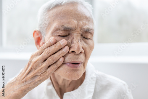 Senior woman touching her face,elderly experiencing pain and numbness in the face,Trigeminal Neuralgia,sudden and severe facial pain,Bell's palsy symptom,facial muscle weakness or paralysis,healthcare photo
