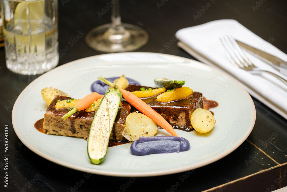 Dish of grilled foie gras with sauce and vegetables