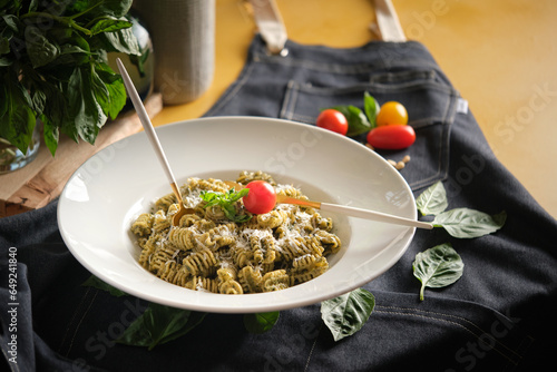 Plate with appetizing pasta radiatori with cheese on table photo