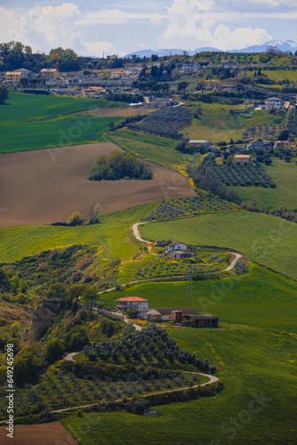 A winding road in the picturesque hills of the Ambruzzo region of Italy, the photo was taken in the rays of the setting sun. view of the village of Montagnola.