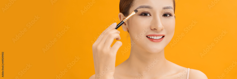 woman applying eyeshadow on eyelid using makeup brush. Web banner. - obrazy, fototapety, plakaty 