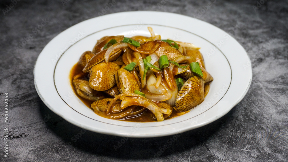 Delicious Batik Clam Served with Sauce on a White Plate Delicious Batik Clam Served with Sauce on a White Plate