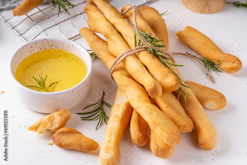 Quadro su tela Italian Mediterranean grissini bread sticks, with aromatic oil and sprigs of ros