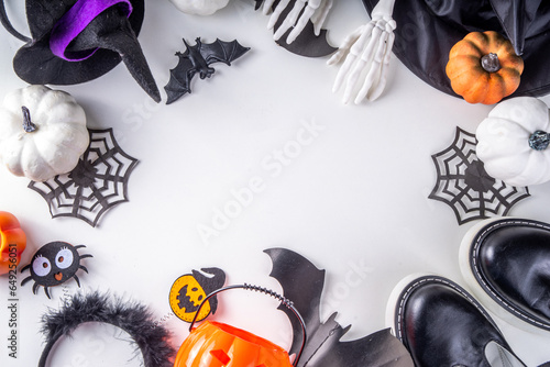Preparations for kids's Halloween party, trick or treat tradition. Traditional children's Halloween costume witch, ghost, skeleton, pumpkin accessories, with candy bucket, decor on white background