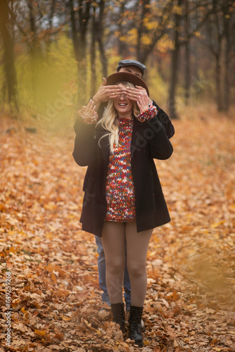 Enjoying couple walking in the park, young woman is pregnant, dressed in autumn clothes and hat, warm colors. Family concept.