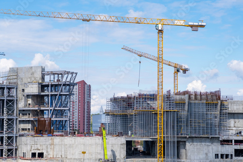 Canvas-taulu A crane and a building under construction against a blue sky background
