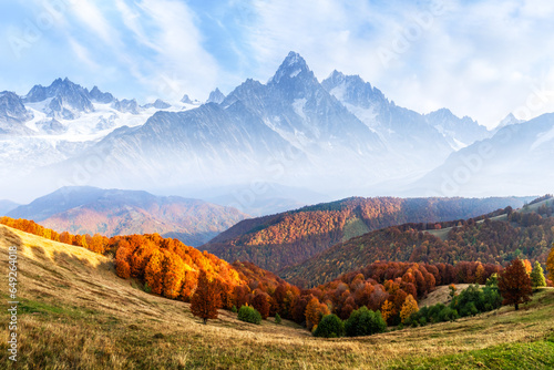 Picturesque autumn meadow infront of high snowy mountains. Landscape photography