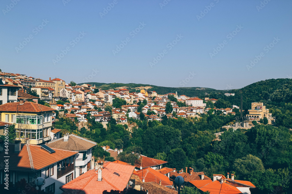 view of summer heat forest surrounded mountain town in bulgaria with many beautiful colorful orange houses 