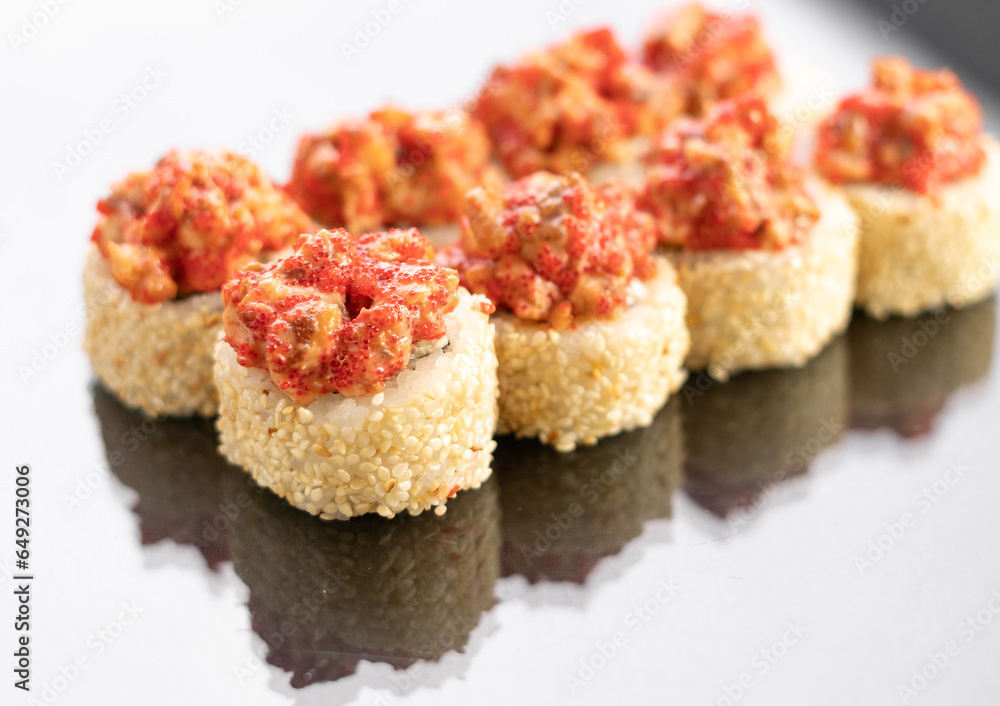 Baked Sushi rolls on white background with reflection, space for text. Japanese food Baked Sushi rolls on white background with reflection, space for text. Japanese food