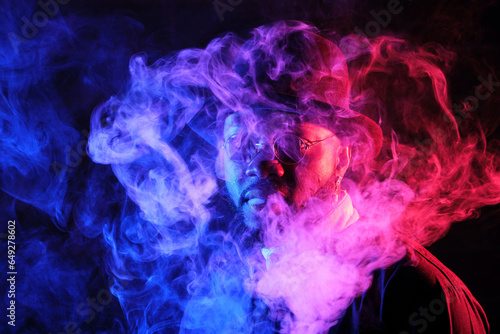 Stylish black man in smoke in neon light