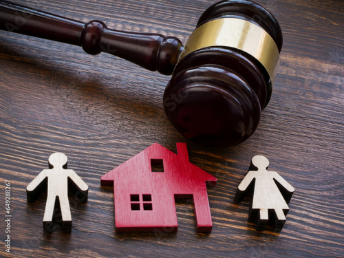 Gavel, figures of a house and divorcing family. Dividing property.